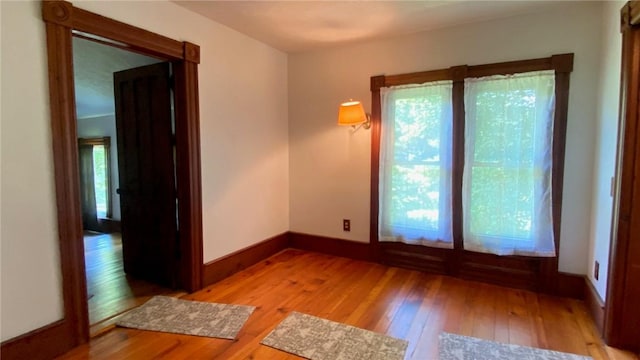 unfurnished room featuring light wood finished floors and baseboards