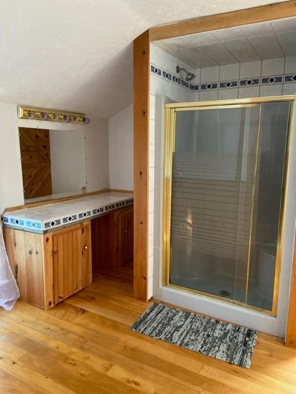 bathroom featuring a shower stall and wood finished floors