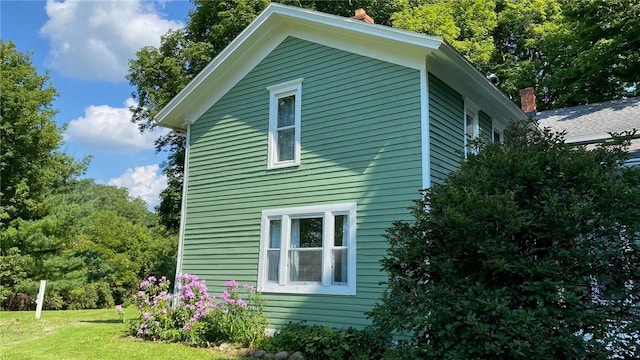 view of property exterior with a lawn