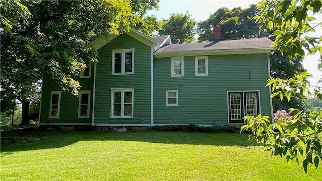 rear view of house with a lawn and a chimney