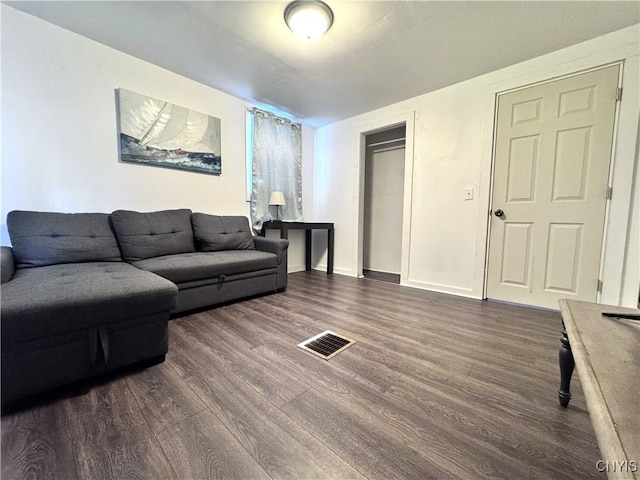 living area featuring baseboards, visible vents, and dark wood-style flooring