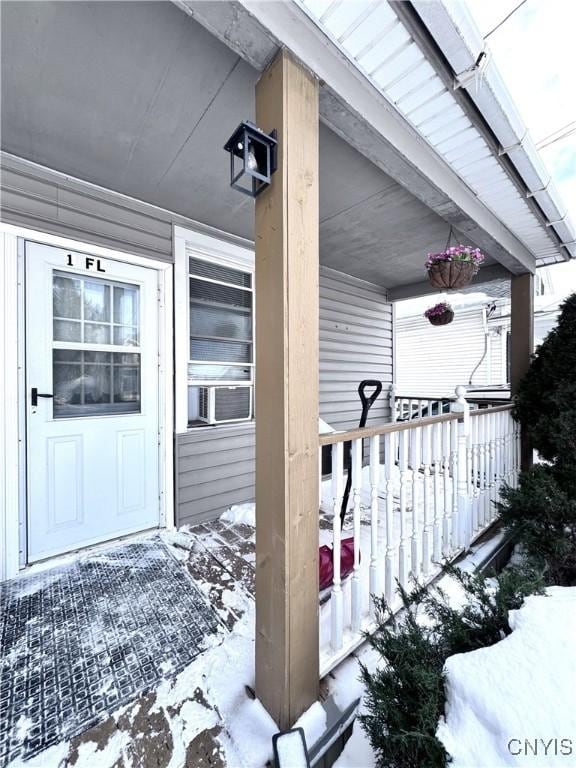 snow covered property entrance with cooling unit