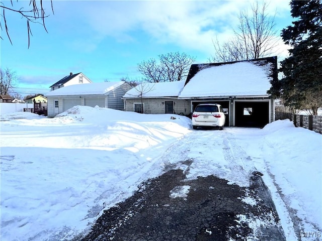 snow covered front of house with an attached garage