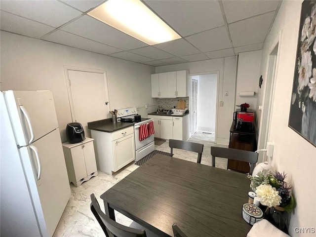 kitchen featuring white cabinetry, white appliances, a paneled ceiling, and marble finish floor