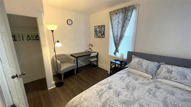 bedroom with dark wood finished floors and baseboards