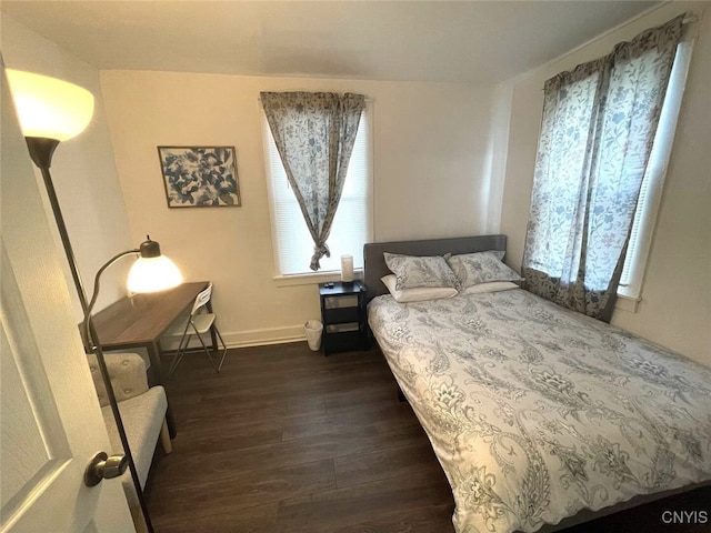 bedroom with baseboards and dark wood-style flooring