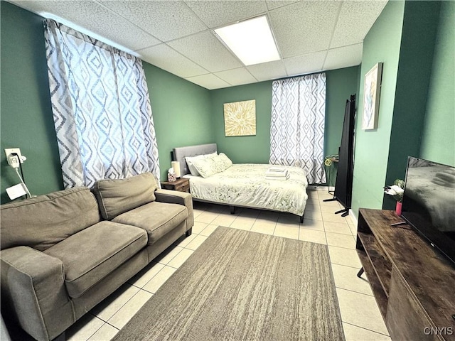 bedroom with light tile patterned floors and a drop ceiling