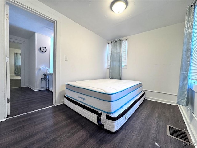 bedroom featuring visible vents, baseboards, and wood finished floors