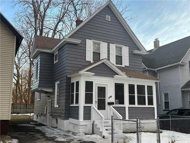 view of front of house with a shingled roof, entry steps, a gate, and fence