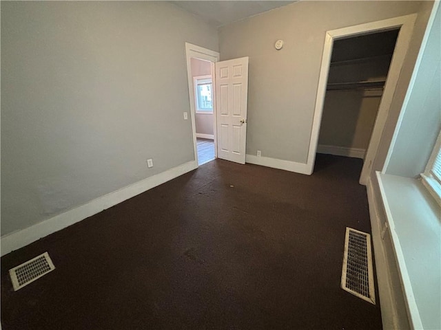 unfurnished bedroom with a closet, visible vents, and baseboards