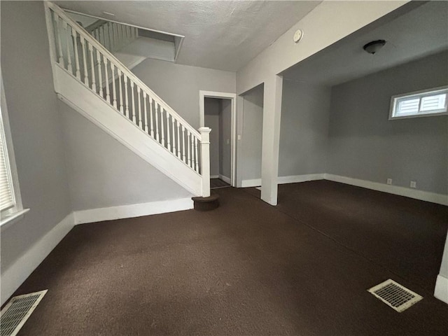 interior space featuring baseboards, stairs, and visible vents