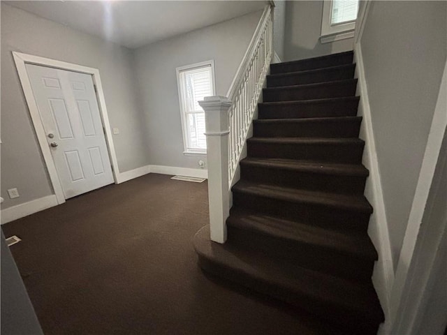 staircase featuring carpet floors and baseboards