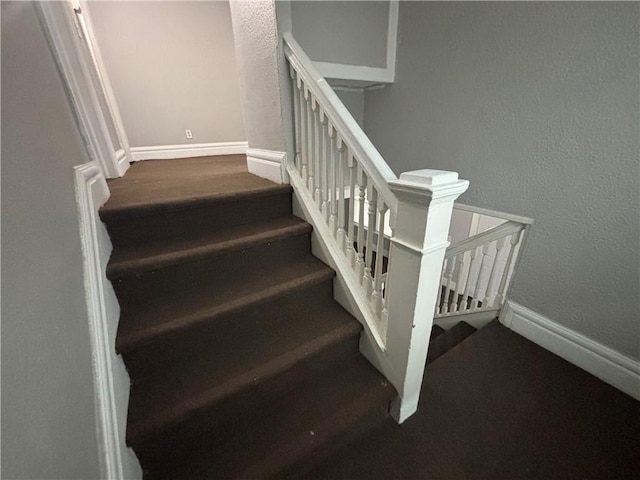 stairs with baseboards and a textured wall