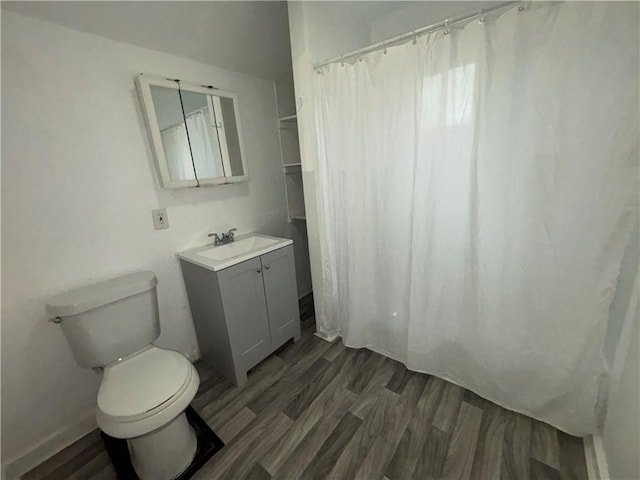 bathroom featuring vanity, curtained shower, wood finished floors, and toilet