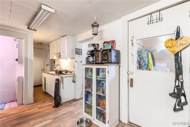 kitchen with light wood-type flooring and white cabinets