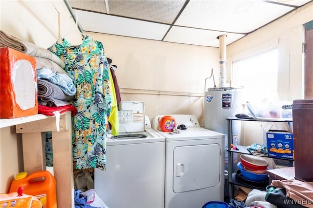 clothes washing area featuring water heater, laundry area, and separate washer and dryer