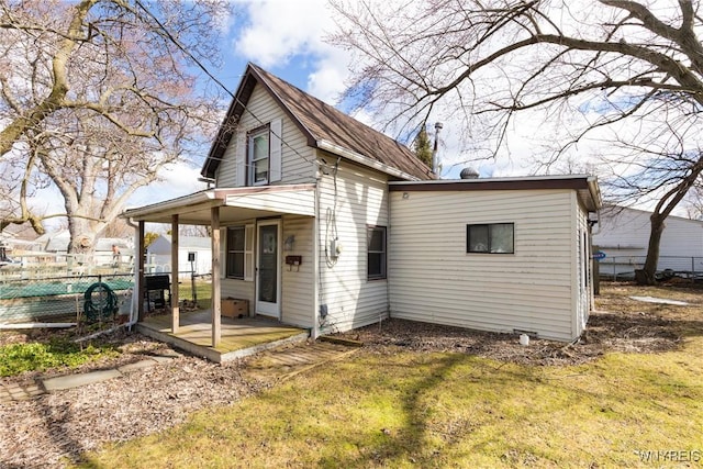 back of property featuring a yard, fence, and a patio