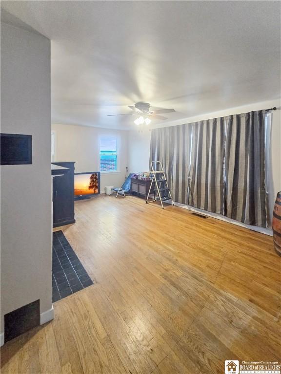 interior space featuring ceiling fan, wood finished floors, and visible vents