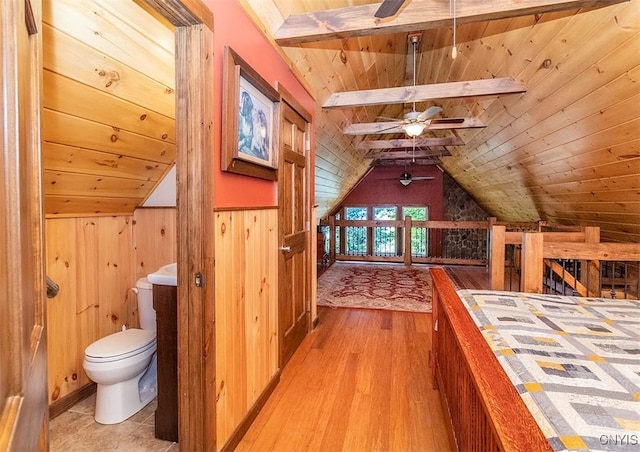 bedroom featuring light wood-style flooring, wooden ceiling, vaulted ceiling with beams, and wooden walls