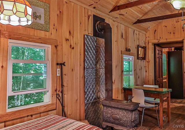 bedroom with freestanding refrigerator, wooden ceiling, wooden walls, and lofted ceiling with beams