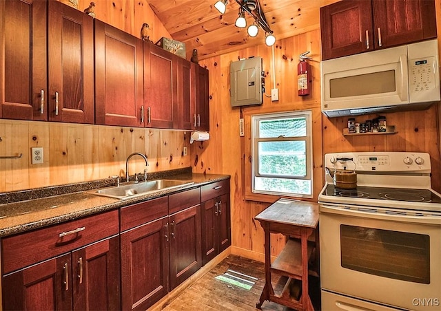 kitchen featuring dark countertops, wooden ceiling, a sink, wooden walls, and white appliances