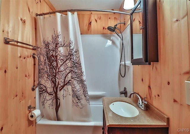 bathroom with shower / bath combo, vanity, and wooden walls