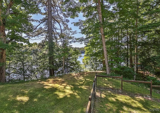 view of yard with a water view and fence