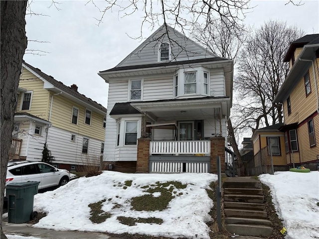 american foursquare style home with a porch and stairs