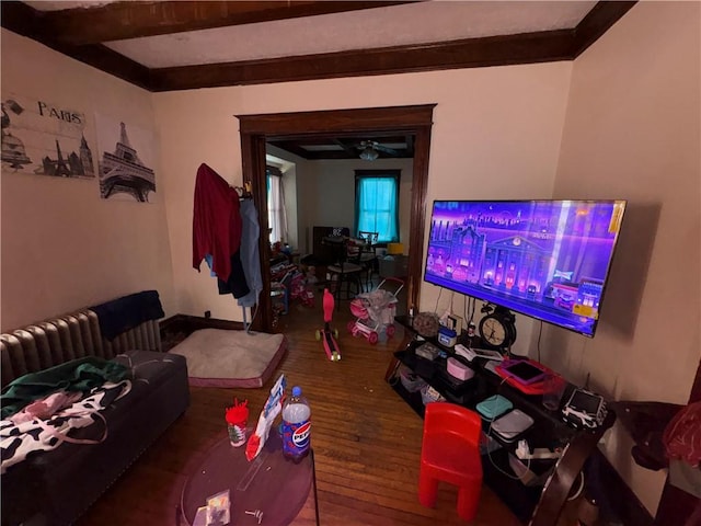 living room featuring ceiling fan, wood finished floors, and beam ceiling