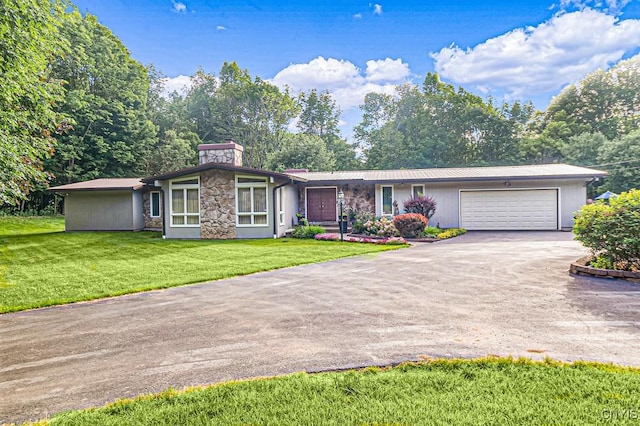 view of front of house featuring a garage, a front yard, stone siding, and driveway