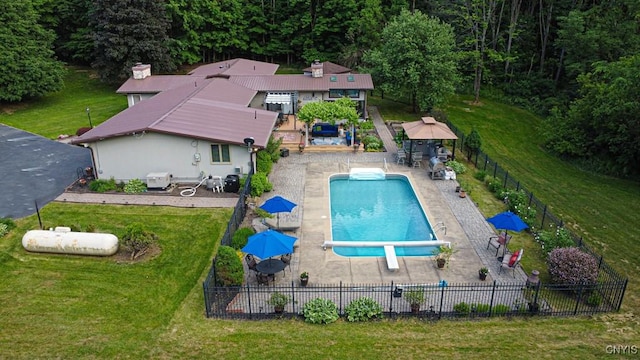 view of swimming pool with a fenced in pool, a patio, a lawn, fence, and a diving board