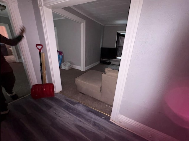 hallway featuring ornamental molding, wood finished floors, and baseboards