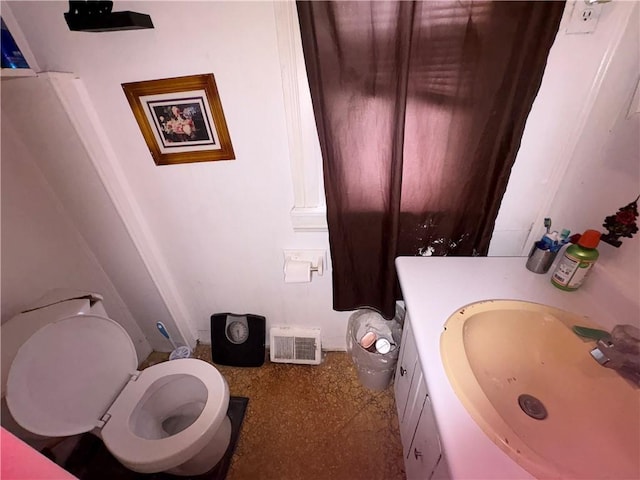 half bath with visible vents, vanity, and toilet