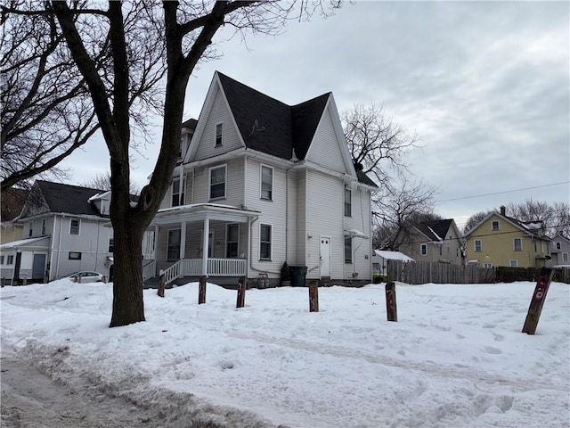 view of front of house featuring covered porch, fence, and a residential view