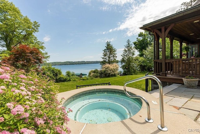 view of swimming pool featuring a patio area, a water view, a yard, and an in ground hot tub