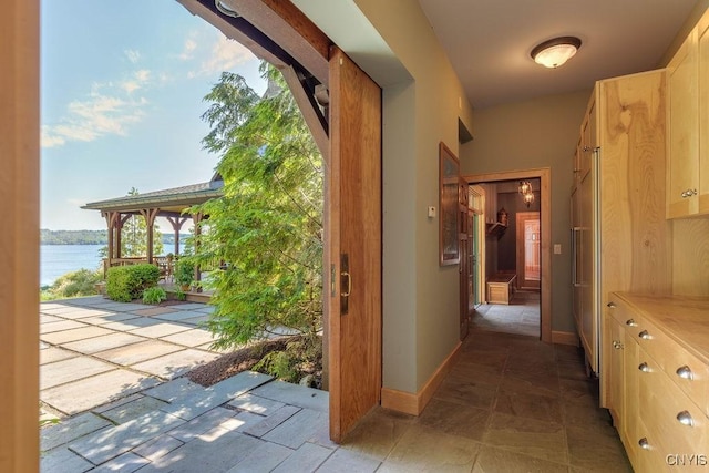 doorway featuring a water view and baseboards