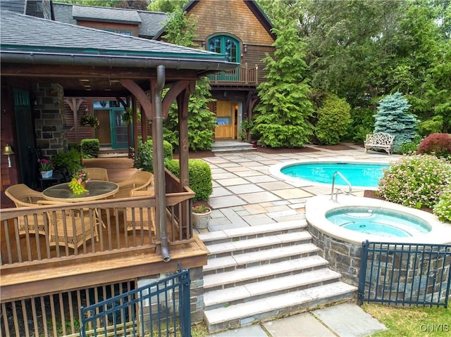 outdoor pool featuring a patio and an in ground hot tub