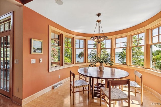 dining room with light wood finished floors, baseboards, and visible vents