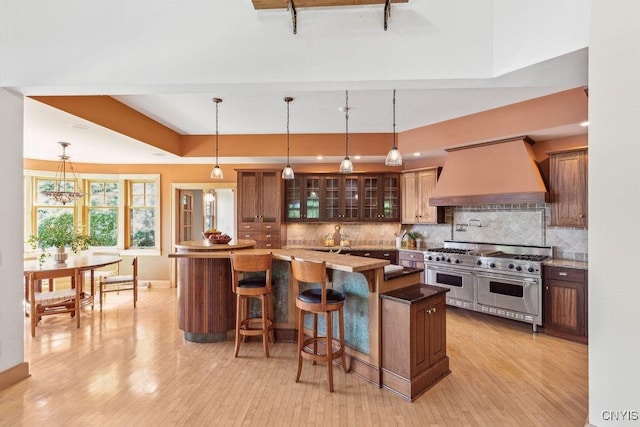 kitchen featuring a center island, double oven range, custom range hood, and backsplash