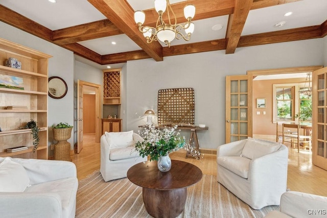 living room featuring an inviting chandelier, coffered ceiling, wood finished floors, and beamed ceiling