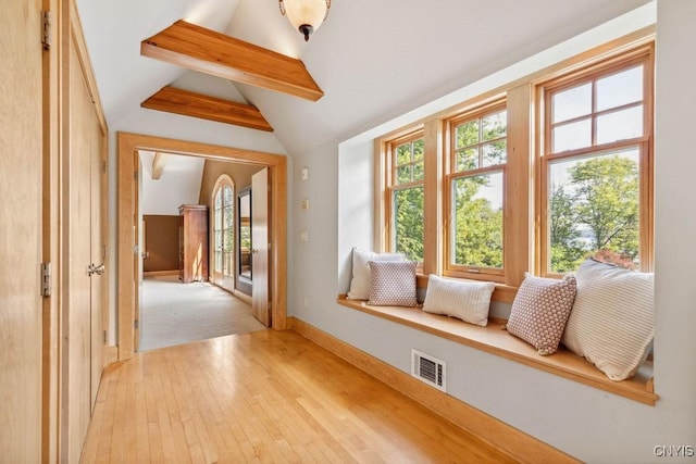 interior space with vaulted ceiling with beams, a healthy amount of sunlight, and visible vents