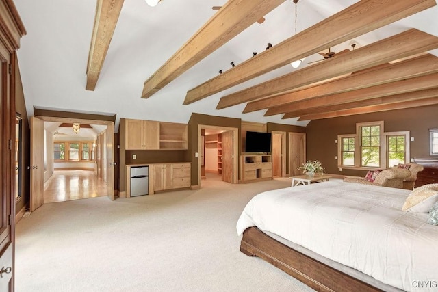 bedroom with multiple windows, light colored carpet, beam ceiling, and refrigerator