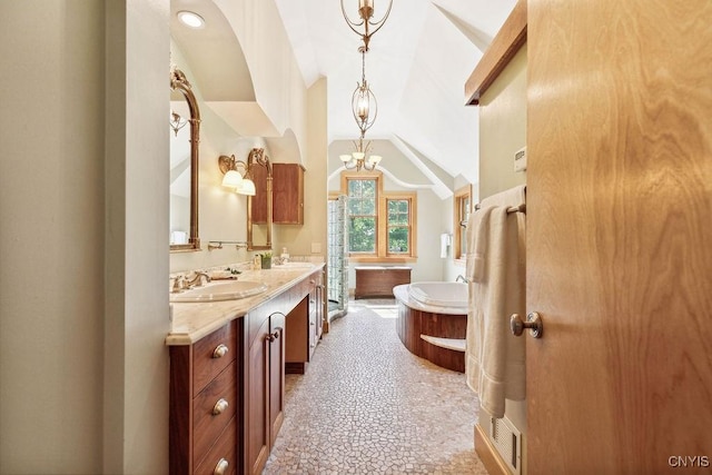 full bathroom featuring double vanity, a sink, a bathing tub, and a notable chandelier