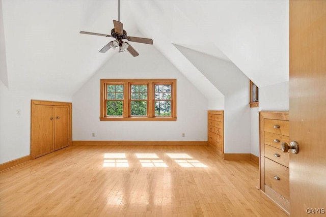 bonus room with light wood-type flooring, baseboards, a ceiling fan, and lofted ceiling