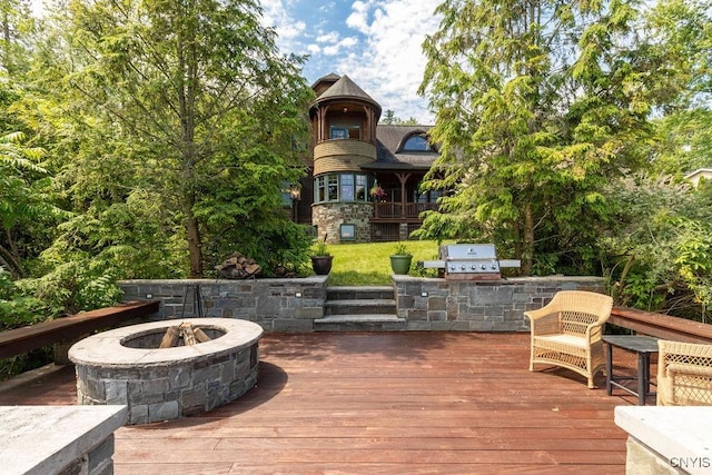 deck featuring a grill, a fire pit, and an outdoor kitchen