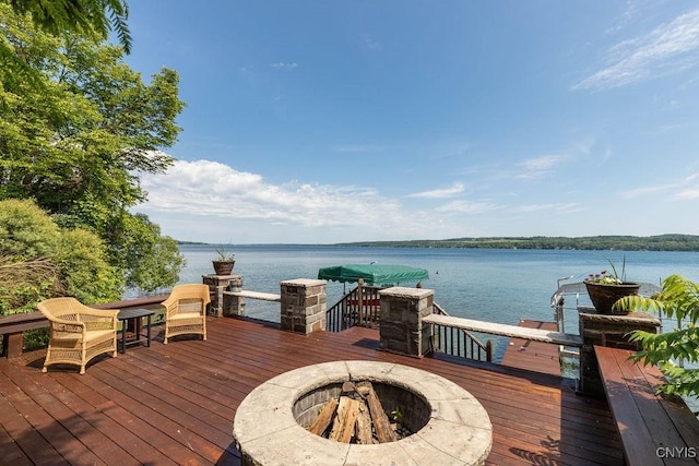 deck with a water view, an outdoor fire pit, and a dock