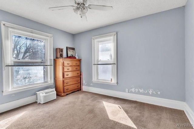 spare room featuring a textured ceiling, plenty of natural light, and baseboards