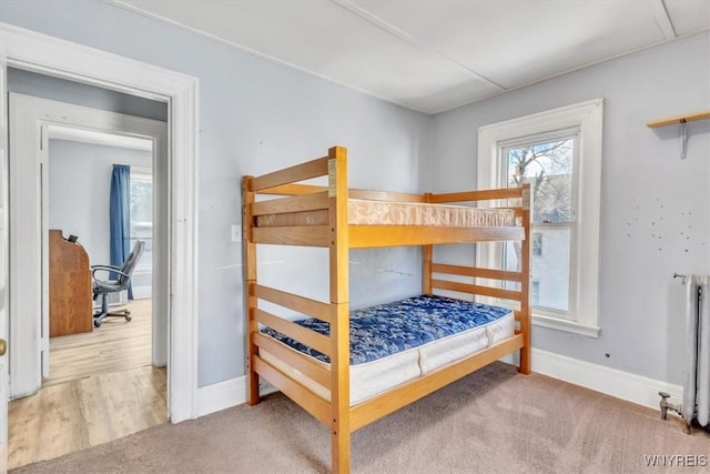 bedroom featuring baseboards, carpet, and radiator