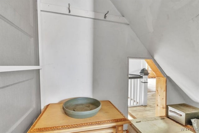 bonus room featuring light wood-type flooring and vaulted ceiling