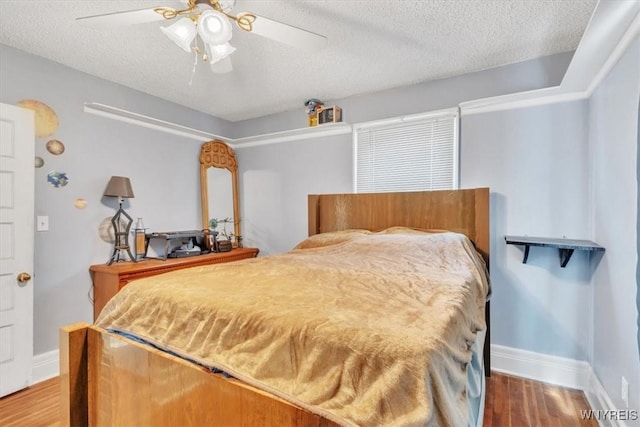 bedroom featuring ceiling fan, a textured ceiling, baseboards, and wood finished floors